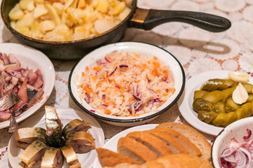 Country dinner with roast potatoes, smoked fish, pickles, bread and coleslaw