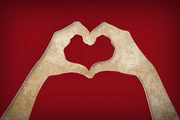 Fototapeta premium paper hands making a heart shape on a brown paper