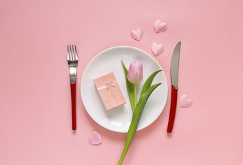 Festive table setting with cutlery, rosy tulip and gift box on p
