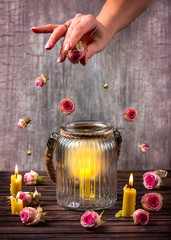 Hand scatter rosebuds above the candles