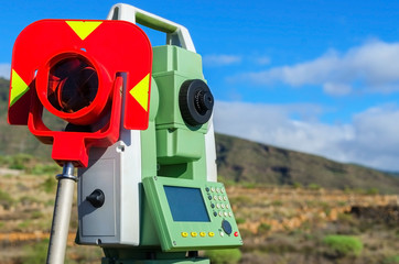 Modern surveyor equipment, theodolite with prism used in surveying and building construction for precise measurement. Total station outdoor at construction site. Copy space.