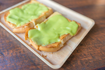 bread custard with topping pandan flavor on wooden table