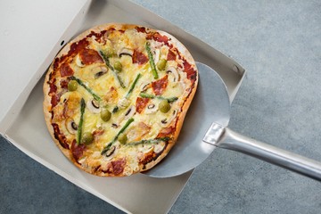 Pizza being placed in a box