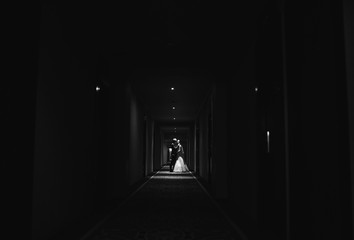 Fototapeta premium Bride and her husband go narrow corridor