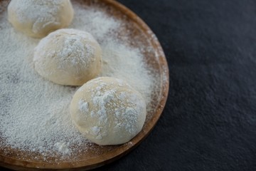 Pizza dough ball on a wooden tray
