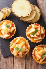 Tart filled with fresh pineapple and jam closeup. vertical top view