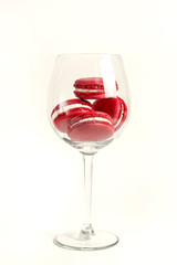 red macaroons in wine glass. valentine's day sweets concept