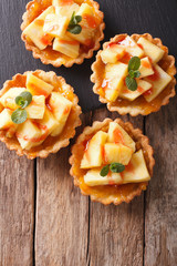 Mini Tart with pineapple and mint close-up. vertical top view