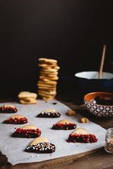 Homemade Heart Shaped Biscuits for Valentine's Day on Baking Paper in Rustic Kitchen