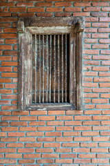 Fototapeta na wymiar Ancient wooden window and iron bars on the brick wall