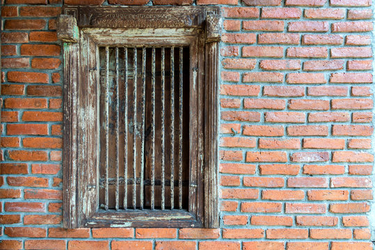 Ancient wooden window and iron bars on the brick wall