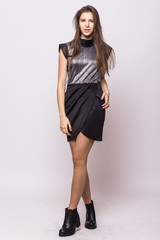 Fototapeta premium Stylish beautiful young woman model in clothes stands on white background