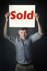 stylish man holding sign with the word Sold
