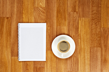 Blank notepad with office supplies and cup of coffee on wooden table. Above view.