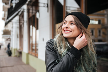 Fototapeta premium Gorgeous young woman wearing hat walking on the street
