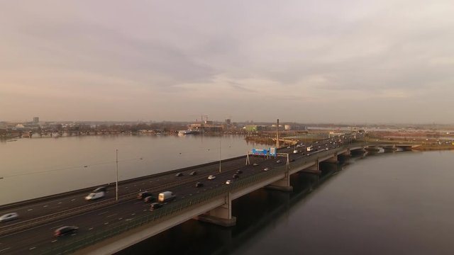 Zeeburg bridge in Amsterdam with afternoon traffic at golden hour, aerial.
