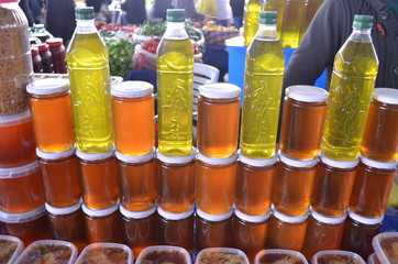 Naklejka premium bottles of olive oil and glass bottles with honey on a stand and stall in bazaar turkey antalya