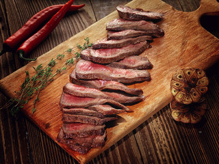 Roast beef steak on a wooden stand.