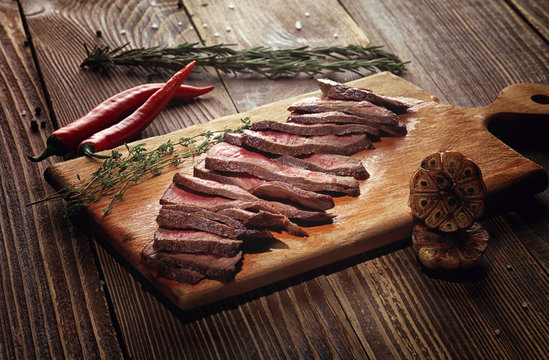 Roast beef steak on a wooden stand.