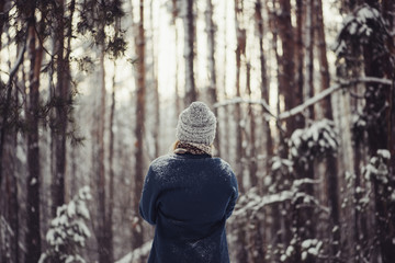 Fototapeta premium Beautiful young woman in the winter snowy forest