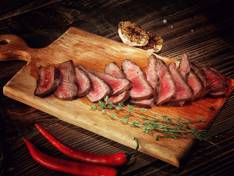 Roast beef steak on a wooden stand.