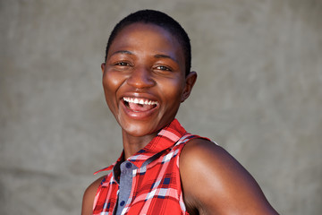 fashionable beautiful woman laughing standing by wall