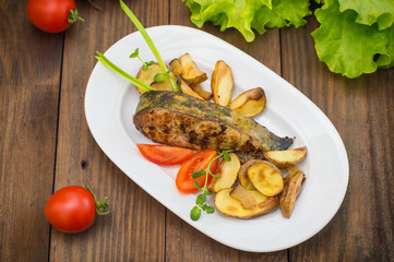 Deep Fried Dolly Fish Steak with French fries on wood background. Top view. Close-up