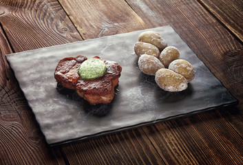 Roasted pork steak on a stone pedestal.