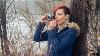 Young woman with camera in nature