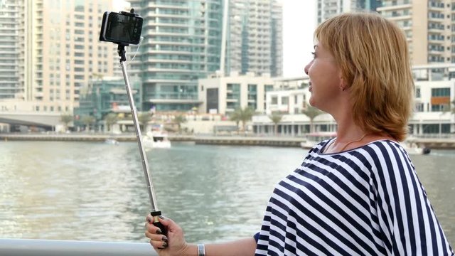  beautiful woman doing selfie with help of monopod in Dubai Marina, UAE 