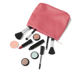 Make up products falling out of a pink leather cosmetics bag, isolated on a white background