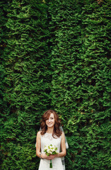 The charming bride stands near trees