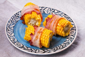 Bacon wrapped corn on blue plate