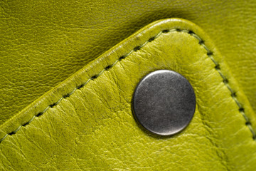 Metal button on green color leather jacket. Lime color. Macro leather jacket detail. Clasp button