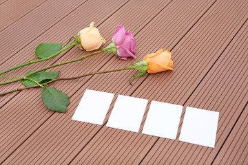Empty notepaper with pink rose flower on wooden.