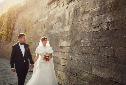 Beautiful Young People Walking Near A High Wall