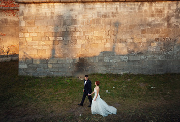 man and his beloved bride are at large walls