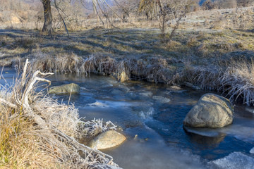Fototapeta na wymiar Frozen river during a cold winter morning. Imressive snowflakes