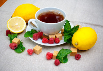 Tea with mint, brown sugar, raspberry and lemon on  table