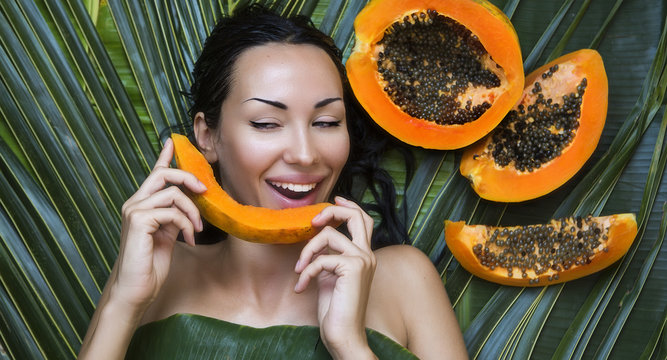 Beautiful Caucasian Woman with fresh fruit Papaya (outdoors). He