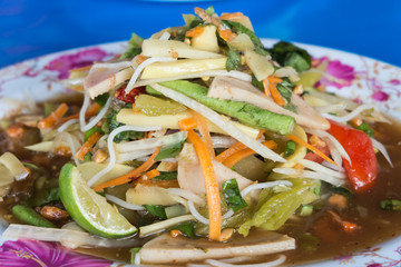 close-up,green papaya spicy salad Thai style on blue background