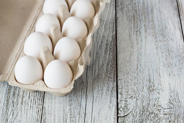 Cardboard egg rack with eggs on wooden table