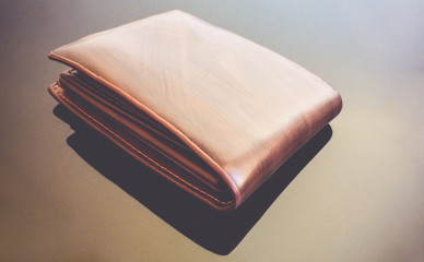 Brown wallet on brown table.