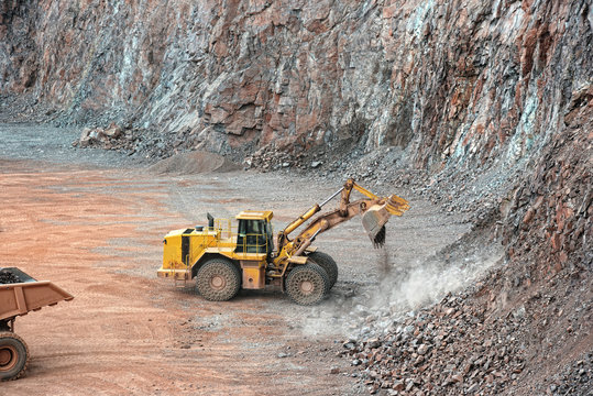 earthmover in a open pit mine quarry. porphyry rock