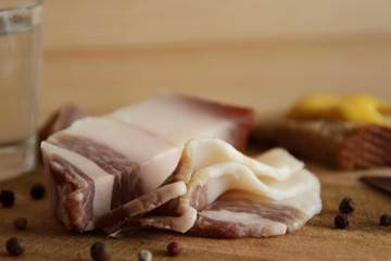salo, becon with pepper, black bread and mustard on the wooden table
