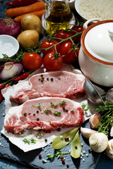 two pieces of raw pork and ingredients for preparation of soup