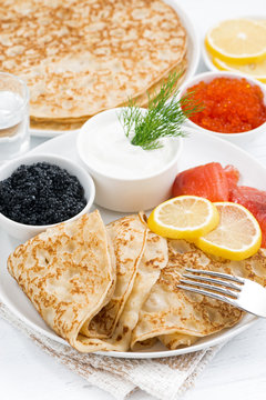 traditional Russian crepes with caviar and salted fish, vertical