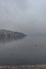Foggy winter scenery at the lake of Kastoria Greece, during a he - 136313504