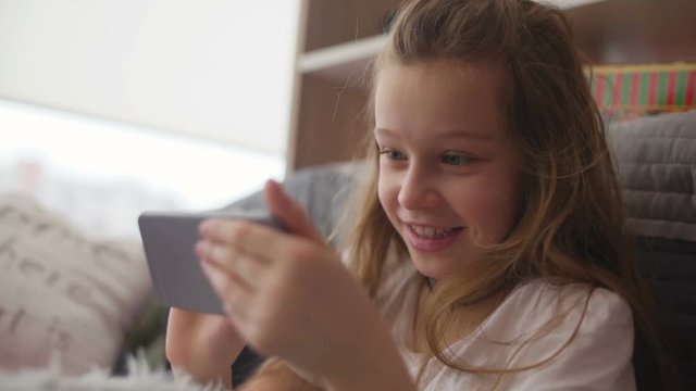 Little girl having fun with game in smartphone
