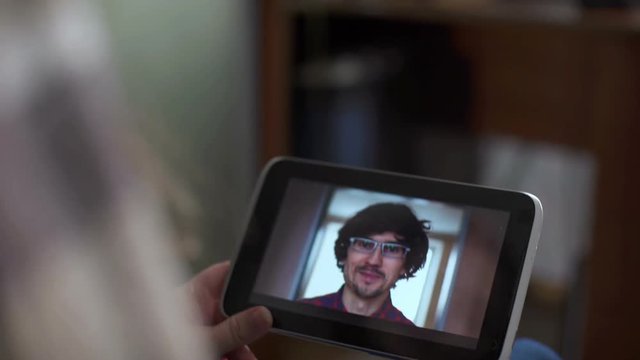 Man and woman communicate through video chat on tablet